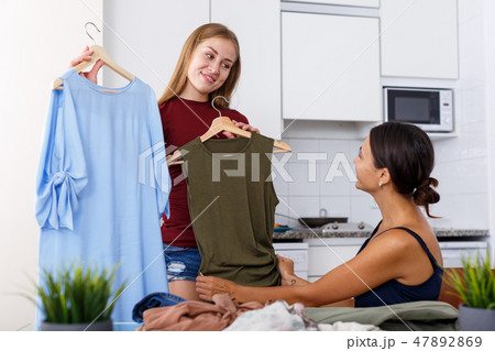 Friends demonstrating each other clothes Friends demonstrating each other clothes 47892869