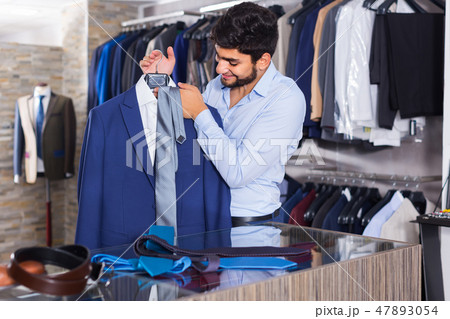 Man 25-33 years old is showing jacket and tie that he chose 47893054