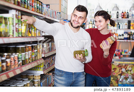 Positive family clients buying tinned food 47893189
