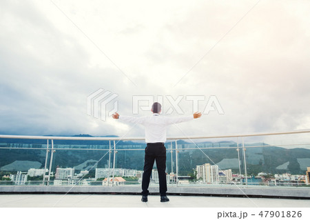 Businessman standing keeping arms raised Businessman standing keeping arms raised 47901826