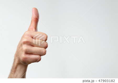 A male hand on a gray background holds 47903182