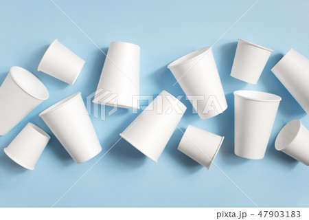 White disposable cups on the light blue background White disposable cups on the light blue background 47903183