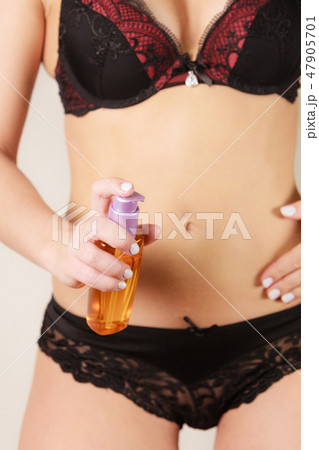 Woman applying moisturizing body oil lotion 47905701