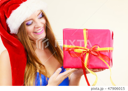 Woman in santa claus hat holds gift box. Christmas time 47906015