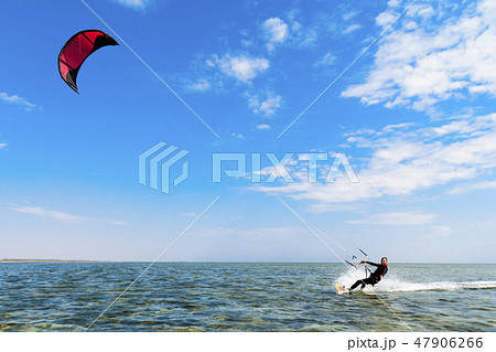 Kitesurfing. Man rides a kite in the sea 47906266