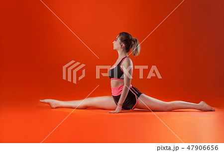 young beautiful dancer posing on isolated red studio background young beautiful dancer posing on isolated red studio background 47906656