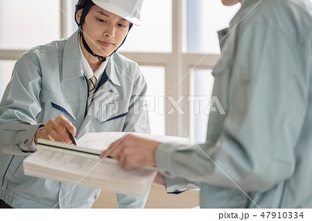 建設現場でヘルメットを被り図面と現場を照合し現場管理する若い男性職員現場監督工事監理者 建設現場でヘルメットを被り図面と現場を照合し現場管理する若い男性職員現場監督工事監理者 47910334