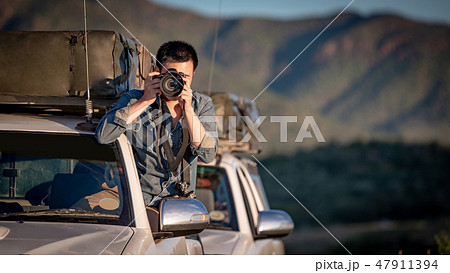 Asian photographer taking photo on car window 47911394