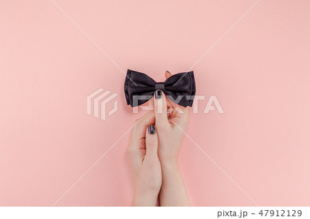 Black bow tie woman hand for men fathers concept Black bow tie woman hand for men fathers concept 47912129