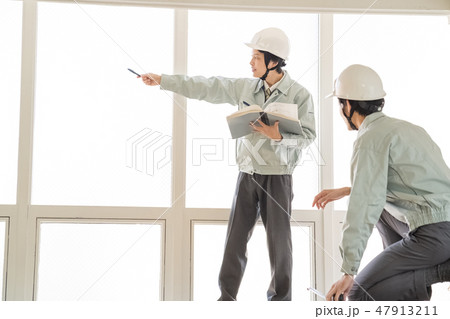 安全パトロールで建築確認申請副本の図面と現場寸法を測定確認するヘルメットの男性検査員二人建築士技術者 安全パトロールで建築確認申請副本の図面と現場寸法を測定確認するヘルメットの男性検査員二人建築士技術者 47913211