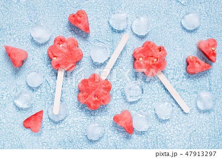 Popslices of fresh watermelon and ice on blue Popslices of fresh watermelon and ice on blue 47913297