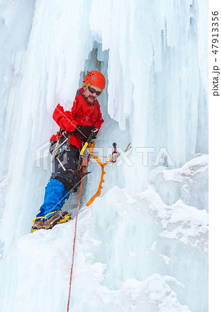 ice climber on the vertical wall of the glacier 47913356