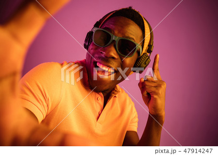The young handsome hipster man listening music with headphones The young handsome hipster man listening music with headphones 47914247