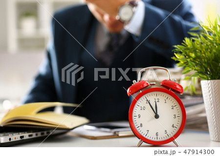 Red alarm clock shows late time closeup Red alarm clock shows late time closeup 47914300