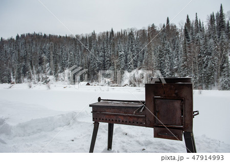 Metal rusty grill in winter forest Metal rusty grill in winter forest 47914993