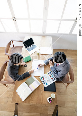 リノベーション改修工事の打ち合わせで色見本を提示し間取りと内装の打ち合わせをする男性ビジネスマン 47916319