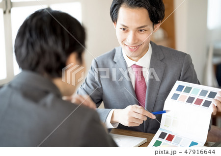 お客様へ色見本を提示し笑顔で内装の提案をする設計事務所の一級建築士男性ビジネスマン 47916644