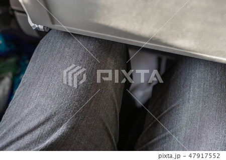 Passenger leg bump into back seat in low-cost commercial airlines. Narrow space for person knee in 47917552