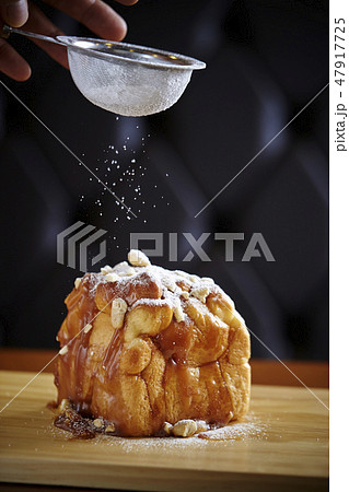 ベーカリー　キャラメルデニッシュに粉砂糖をかける男性 47917725