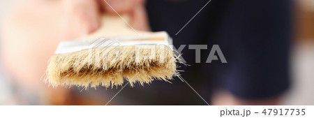 Arm of smiling worker hold brush closeup Arm of smiling worker hold brush closeup 47917735