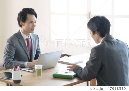 明るい窓際の席でミーティングをする若い男性ビジネスマン二人 明るい窓際の席でミーティングをする若い男性ビジネスマン二人 47918550