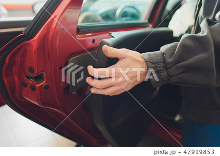 Mechanic installing car central door lock motor. 47919853