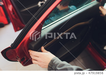 Mechanic installing car central door lock motor. Mechanic installing car central door lock motor. 47919856