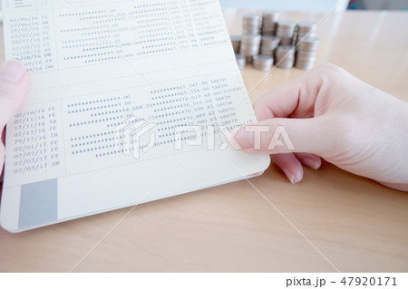 Woman hold passbook on hand, coins background 47920171