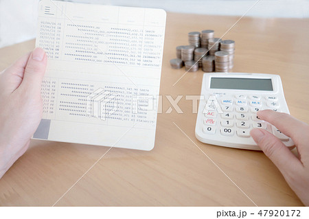 Women checking amount in bank account passbook 47920172
