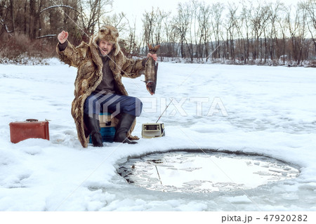 Elderly man on winter fishing. 47920282