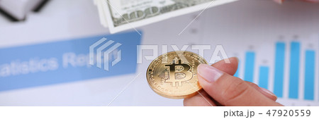 Hands with a coin bitcoin and fan of dollars 47920559