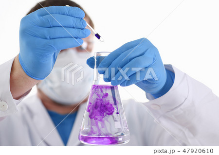A male chemist holds test tube of glass A male chemist holds test tube of glass 47920610