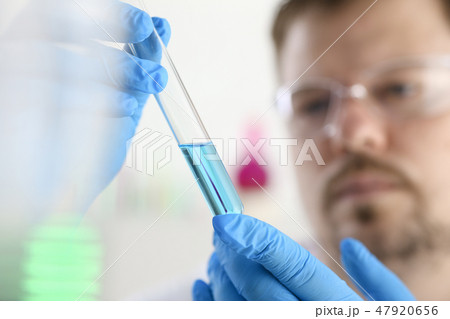 A male chemist holds test tube of glass A male chemist holds test tube of glass 47920656