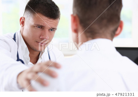 Friendly male doctor hold patient shoulder Friendly male doctor hold patient shoulder 47921331
