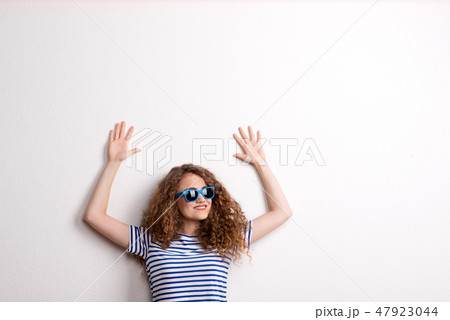 Young beautiful cheerful woman with sunglasses in studio. Copy space. Young beautiful cheerful woman with sunglasses in studio. Copy space. 47923044
