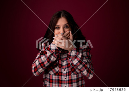 girl closes hands over her mouth in shock by what he heard. Keep secret girl closes hands over her mouth in shock by what he heard. Keep secret 47923626