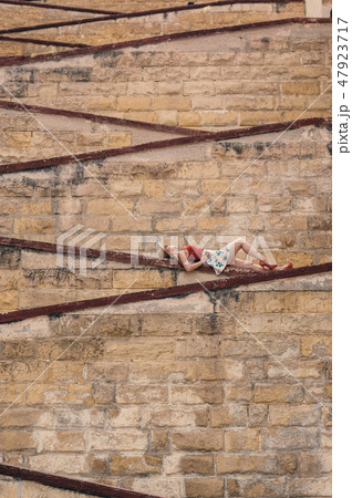 Young girl laying on the city walls Young girl laying on the city walls 47923717
