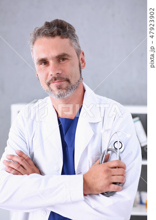 Handsome mature smiling male doctor with arms crossed on chest 47923902