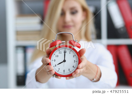 Smiling business woman holding in hand clock 47925551