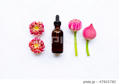 Lotus essential oil with lotus flowers on white. 47925782
