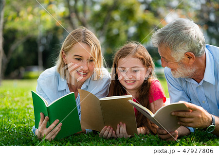 Happy family read books together in park garden. 47927806