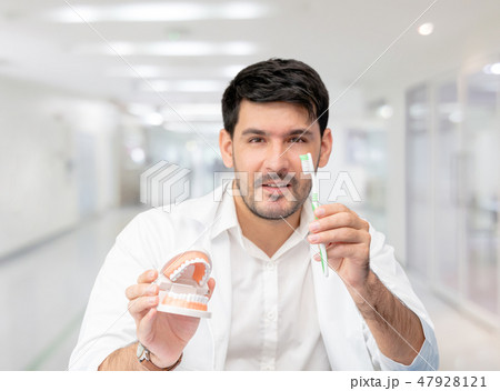 Dentist with toothbrush, focus at toothbrush. Dentist with toothbrush, focus at toothbrush. 47928121