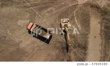 Aerial photo of excavator pours sand into the truck. Aerial photo of excavator pours sand into the truck. 47936199