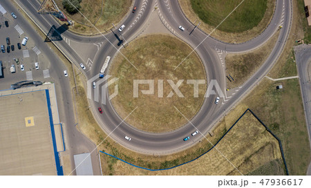 Aerial view of transport junction, traffic cross road junction day view from above with circle road. Aerial view of transport junction, traffic cross road junction day view from above with circle road. 47936617