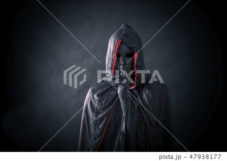 Scary figure with black mask in hooded cloak Scary figure with black mask in hooded cloak 47938177