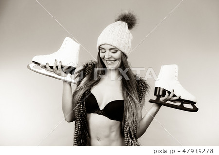Woman wearing bra and holding ice skates Woman wearing bra and holding ice skates 47939278
