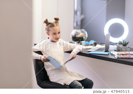 Cute blue-eyed long-haired girl with bright earrings sitting in the chair Cute blue-eyed long-haired girl with bright earrings sitting in the chair 47940515