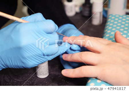 Woman hands in a nail salon receiving a manicure by a beautician 47941817