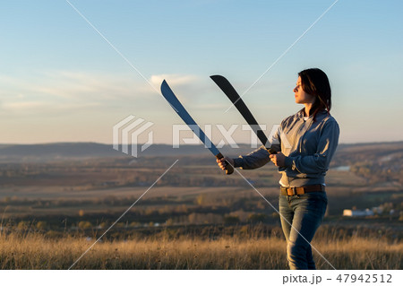 Girl on a high mountain trains with a machete 47942512