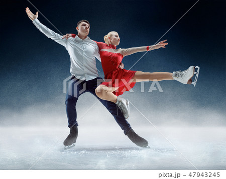 Professional man and woman figure skaters performing on ice show 47943245